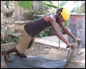 flattening steel drum in Haiti - Haitian metal tropical designs . - www.tropicdecor.com